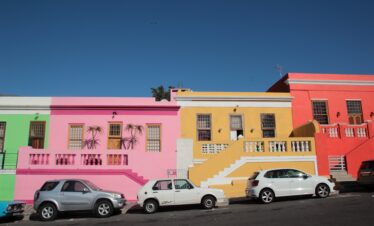 Colourful houses of BoKaap with cars parked in row