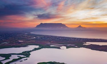 sunset with lakes in front and mountain in background
